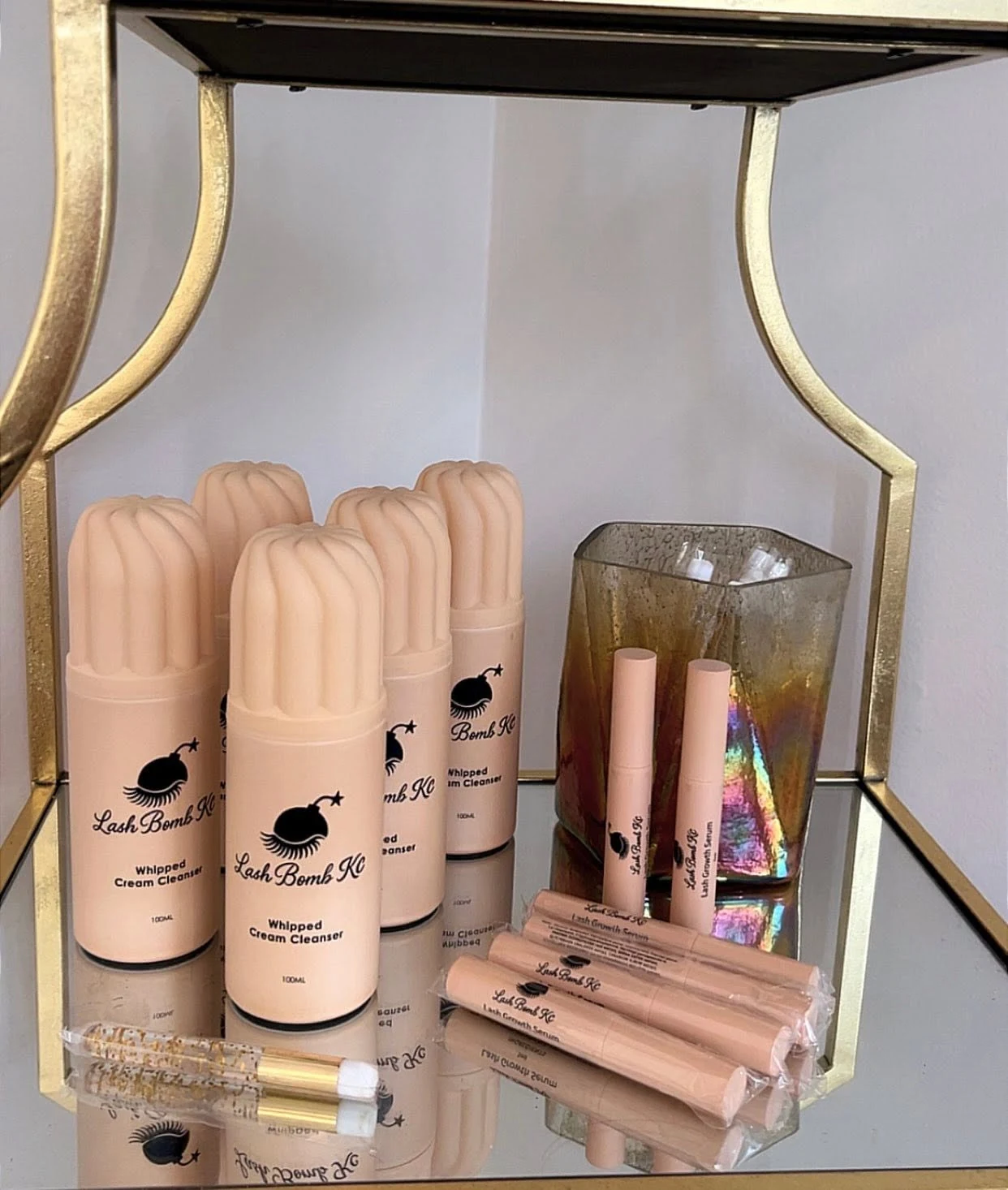 Lash Bomb KC lash cleansers and pink beauty essentials displayed at the studio