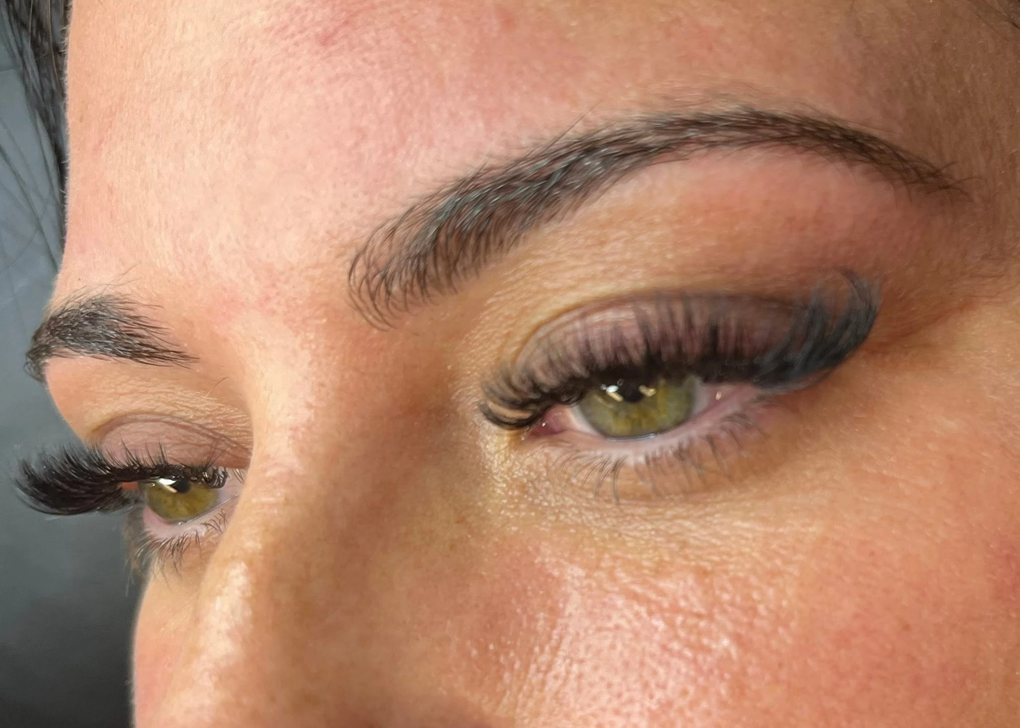 Lash Bomb KC client with hazel eyes showing curled, defined lash extensions